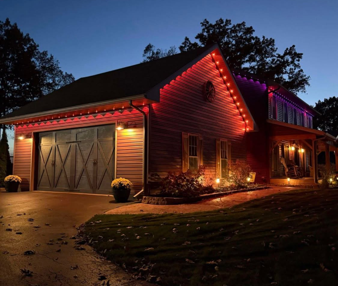 Autumn red and warm LED lighting on log-style home with garage