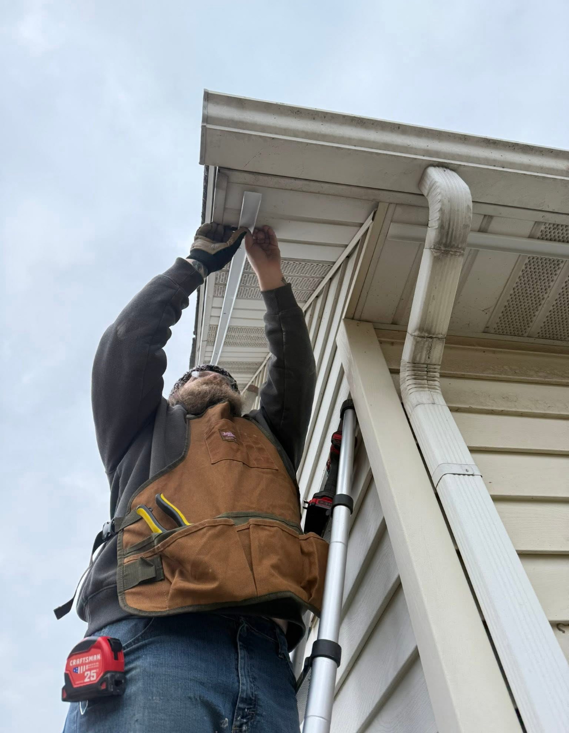 Kingdom Shine technician installing permanent LED lighting under soffit