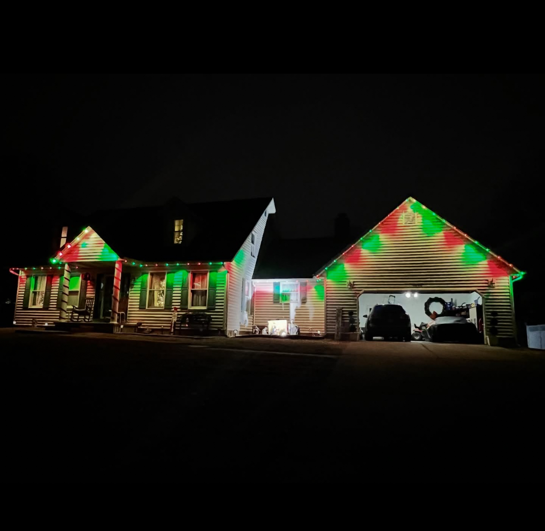Red and green Christmas LED lights on home with garage